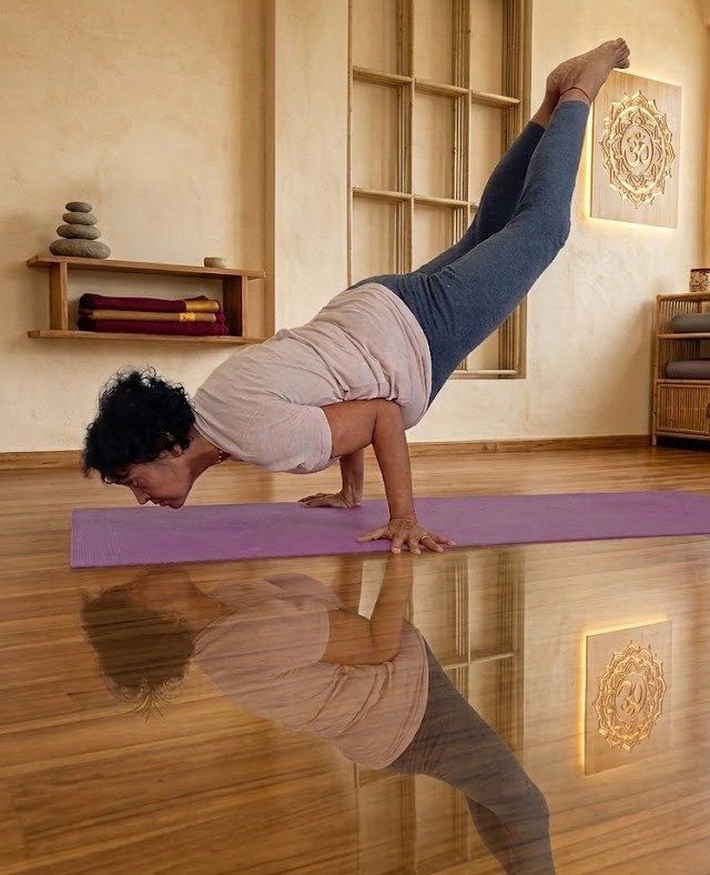 Practitioner balancing parallel to the floor on the hands in Mayurasana, the peacock pose